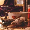 Symbolic Ritual Table Gallery Image | Meriem Chrrouhi Spiritual tabletop with an animal skull, ivory bowl, purple goblet, herbs, candle and cards.