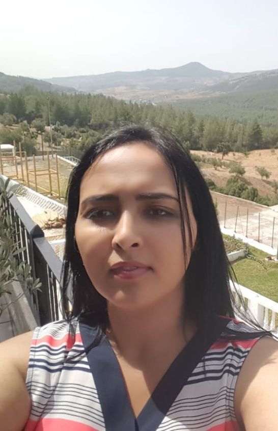 Meriem Chrrouhi outdoors with wooded hills and mountains in the background.