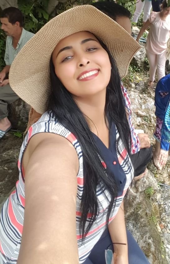 Meriem Chrrouhi smiling outdoors in a wide-brimmed straw hat.