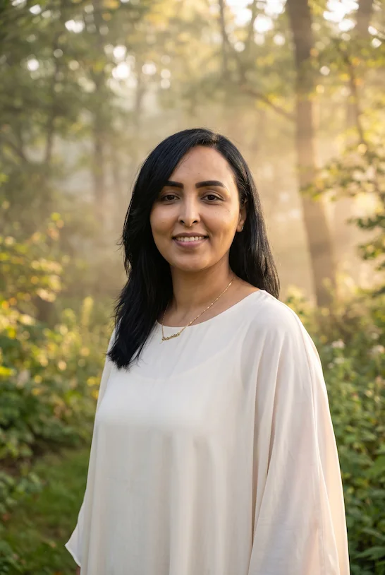 Meriem Chrrouhi in an ivory dress in a woodland garden with soft morning light.