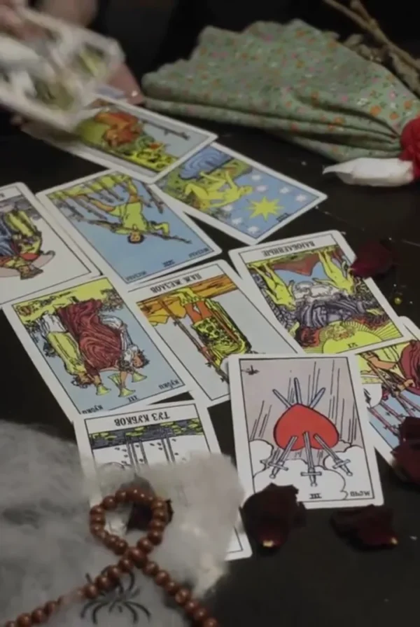 Tarot Spread for Reflection — Video Preview Tarot spread with The Star, Three of Swords and other cards beside beads and rose petals on a dark table.