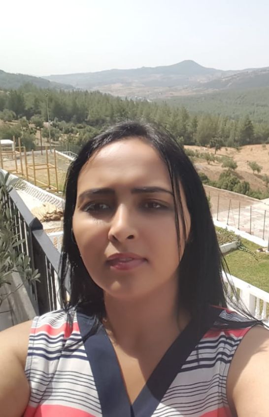 Meriem Chrrouhi outdoors with wooded hills and mountains in the background.