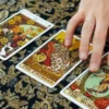 Tarot Card Interpretation — Video Preview | Personalized Tarot Reading Hand resting beside The Empress, The World and Ten of Pentacles tarot cards on patterned fabric.